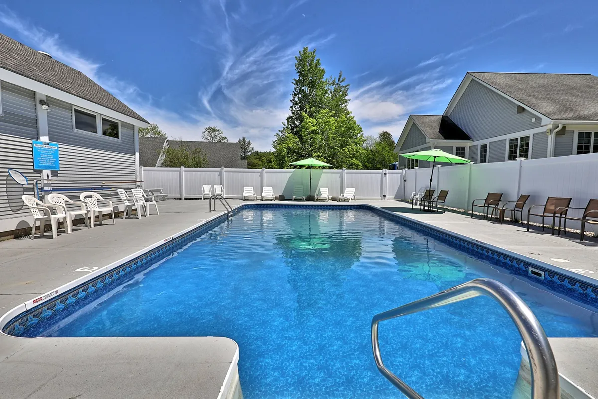 A bright and welcoming view of the property’s pool area, with multiple lounge chairs and umbrellas arranged around the water. The image evokes a sense of community and relaxation, perfect for group gatherings or quiet afternoons.