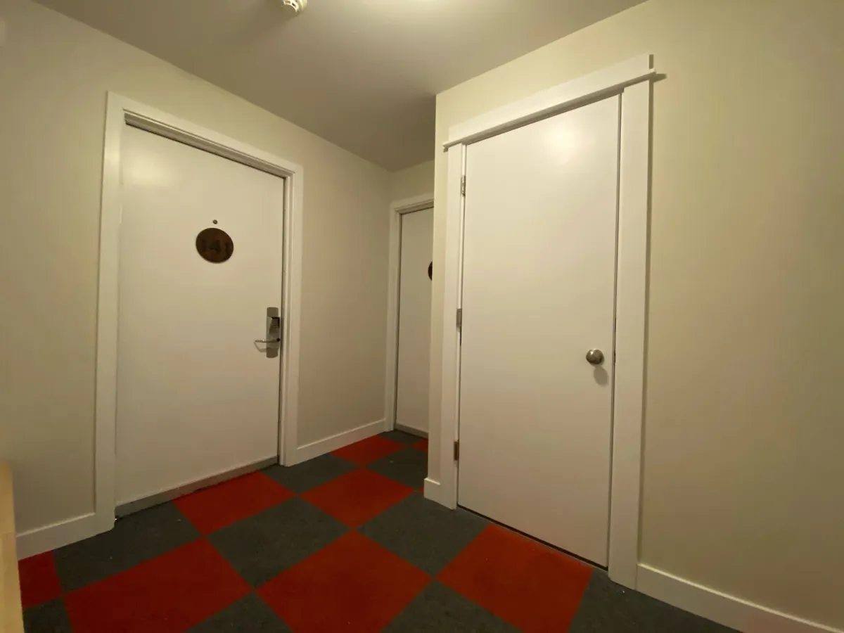 A view of interior doors and a distinct flooring pattern, suggesting the transition between different spaces within the property. The scene hints at movement, entry, and the connection between inside and out—as well as potential access to amenities like balconies or outdoor areas.